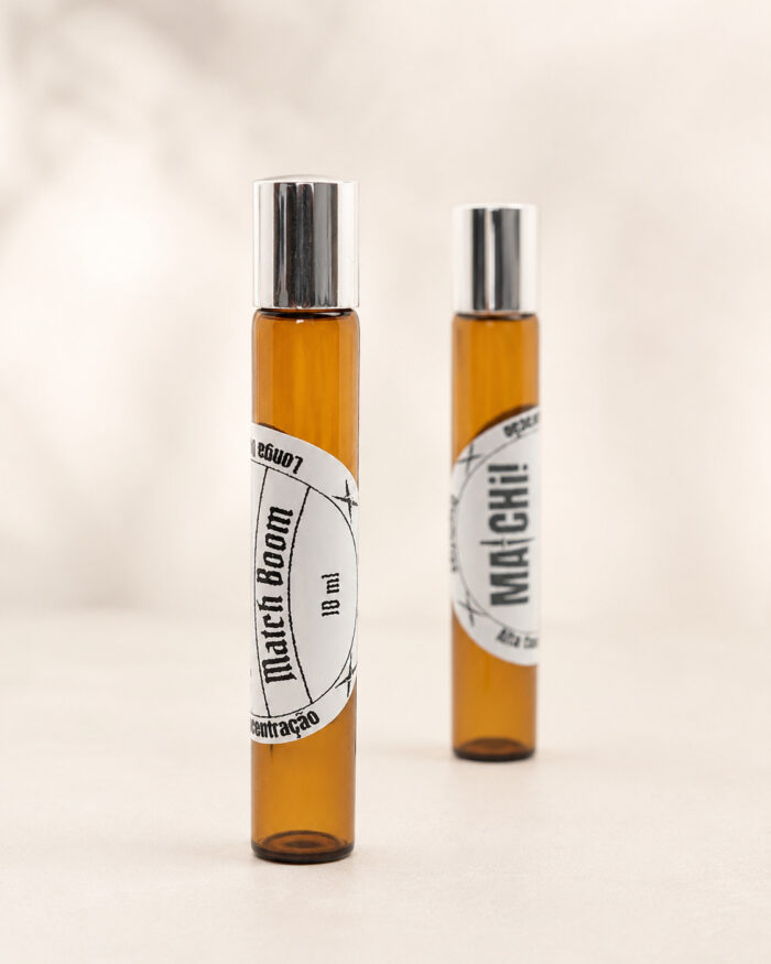 dois frascos de perfume roll on em vidro âmbar com tampa cromada e rótulos brancos match boom e matchii