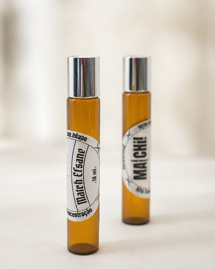 dois frascos de perfume cor âmbar com tampas cromadas posicionados um na frente e outro ao fundo com respectivos adesivos redondos brancos match efsane e o do fundo matchii