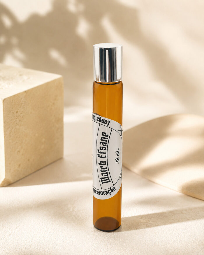 frasco de perfume de vidro roll on âmbar com tampa cromada e rótulo branco match efsane na posição vertical em cima de mesa de granito bege claro