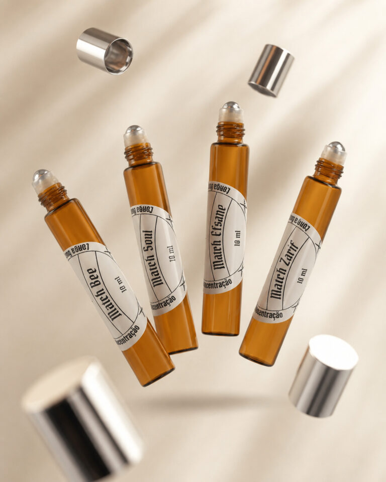 quatro frascos de vidro cor âmbar de Perfumes roll on com aplicadores de esfera metálica a mostra e tampas suspensas efeito gravitacional