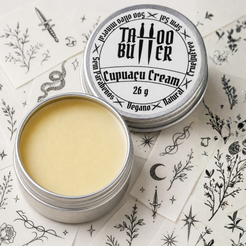 Latinha de alumínio expondo manteiga hidratante para tattoo ao lado da tampa de alumínio com rótulo redondo branco tattoo butter cupuaçu cream sobre papel com artes para tattoo